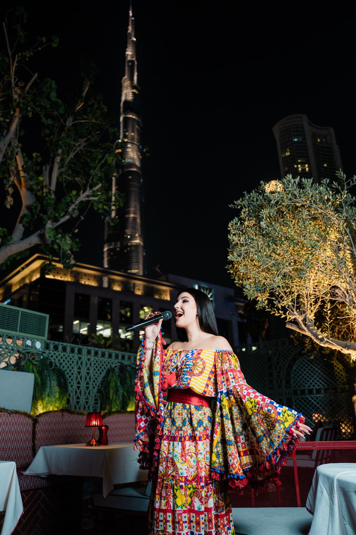 Carol Magagna performing on a Dubai rooftop with the Burj Khalifa behind her