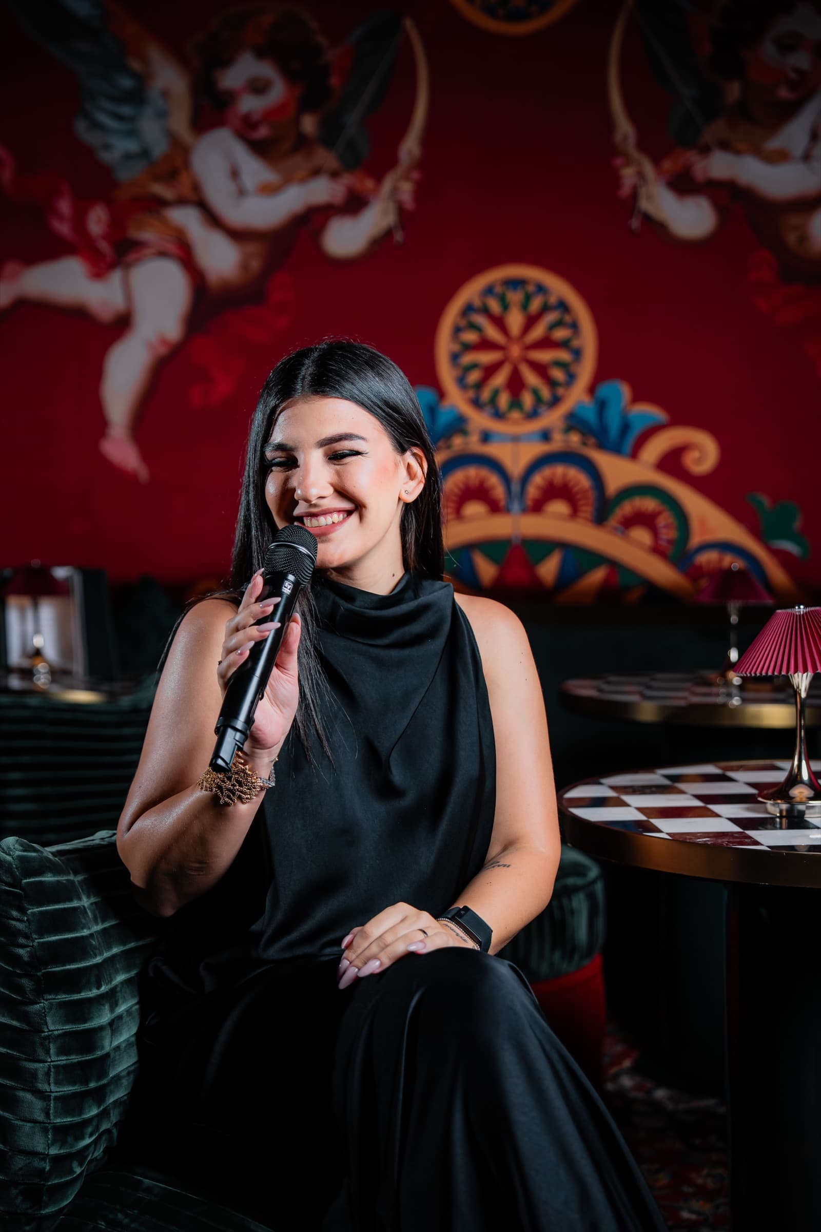 Carol Magagna singing in a black dress in a candlelit lounge