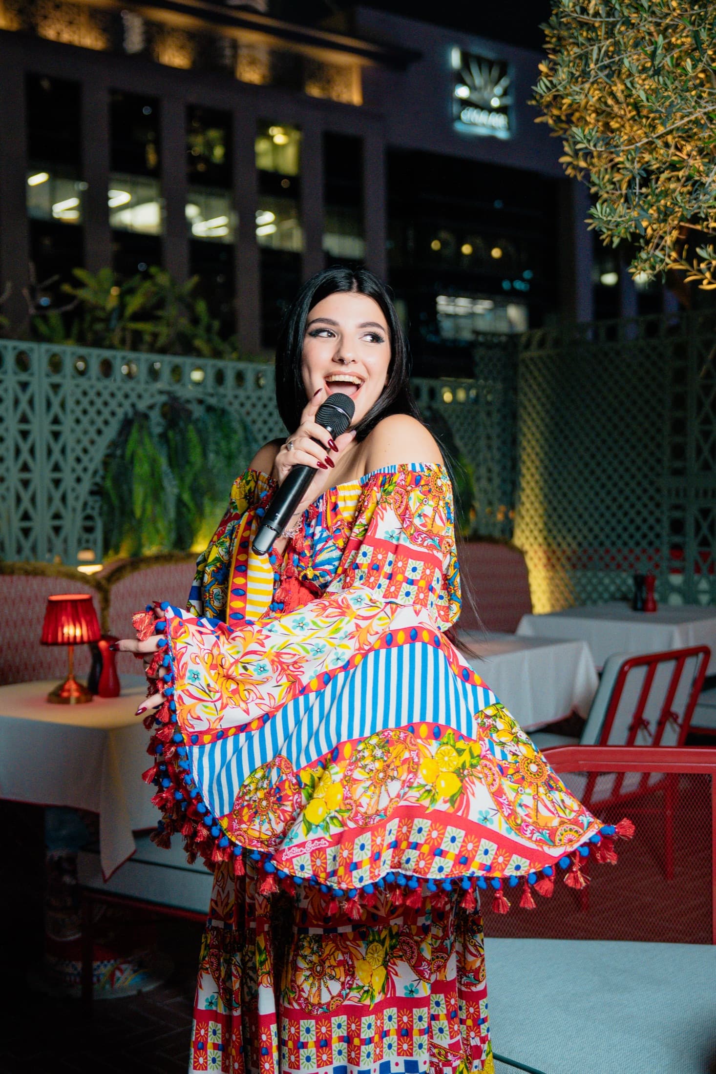 Carol Magagna performing live in a printed gown on a Dubai rooftop